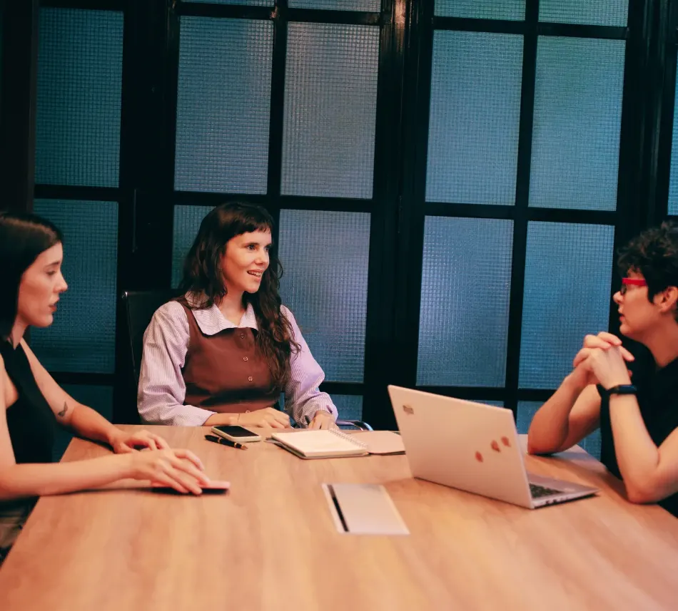 Reunión de trabajo de Proyecto SHE alrededor de una mesa de madera