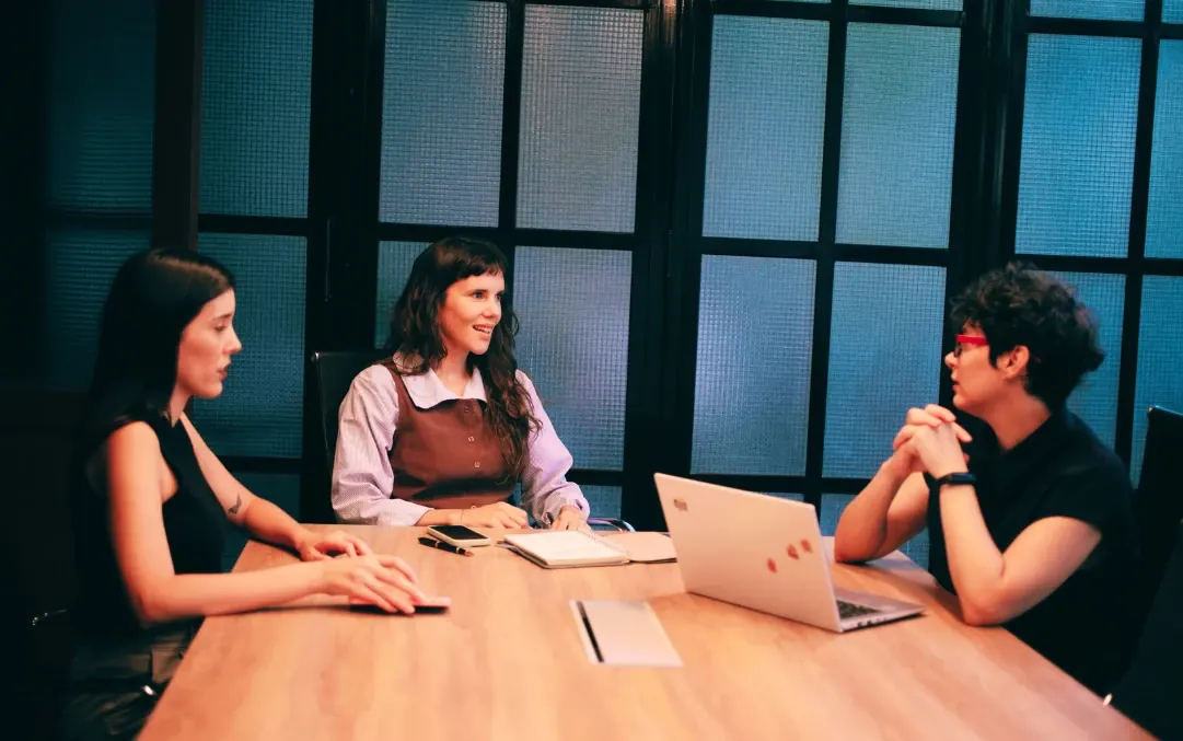 Las tres socias de Proyecto SHE trabajando en una reunión con una notebook